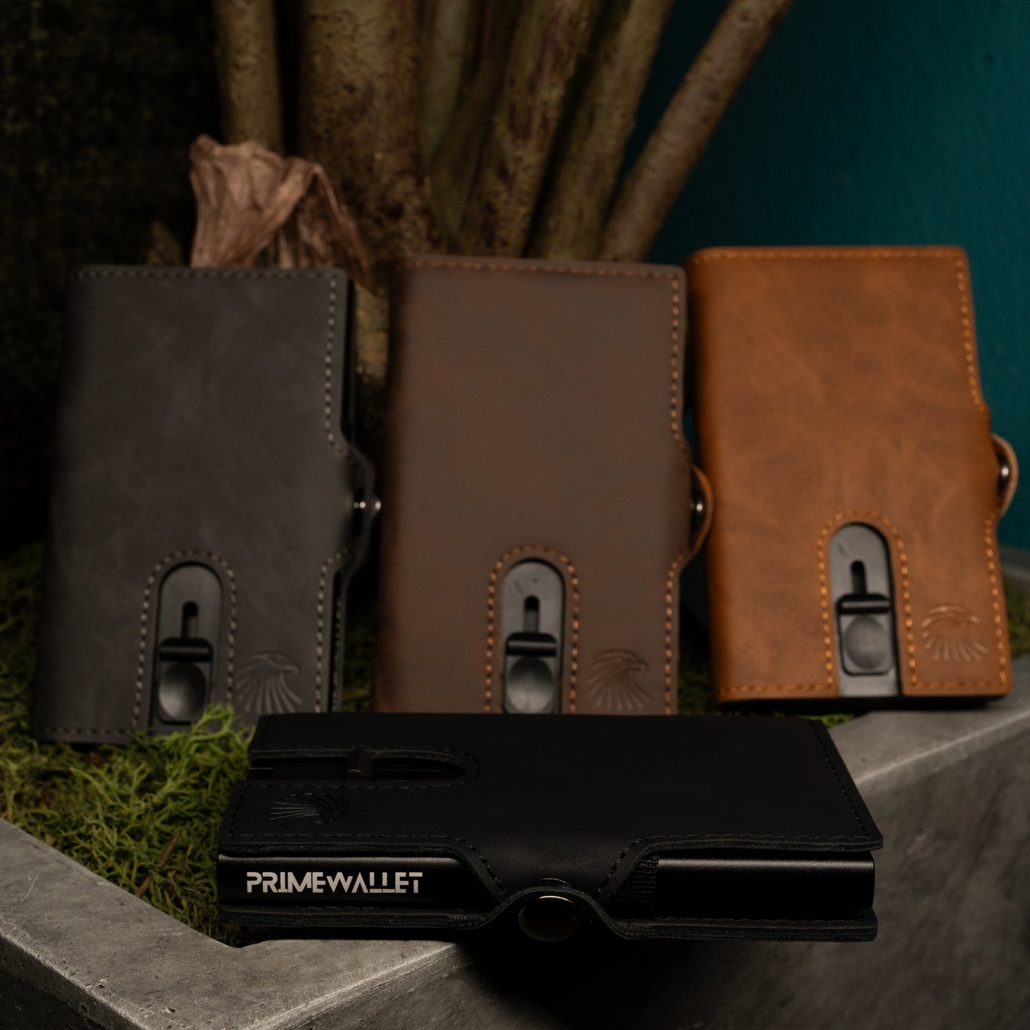 Vier Slim Wallet Push in Schwarz, Braun, Grau und Dunkelbraun – stilvolle Geldbörsen mit RFID-Schutz, präsentiert in natürlicher Umgebung.