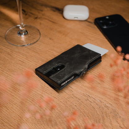 Elegantes Slim Wallet Push in Grau auf Holz mit dezenter Prägung – trendige Geldbörse mit smarter Kartenfunktion für den Alltag.