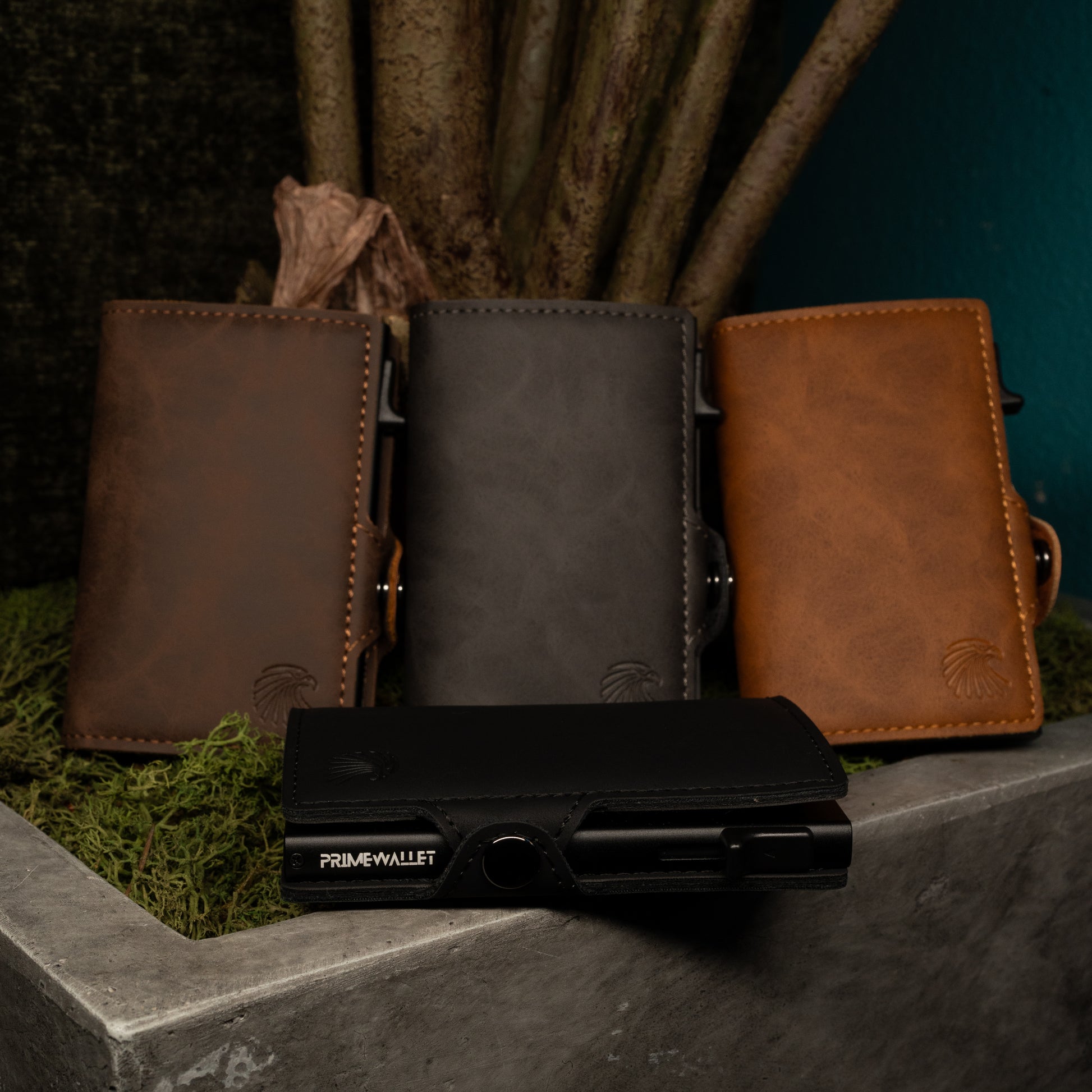 Vier Slim Wallets in Schwarz, Braun, Grau und Dunkelbraun – stilvolle Geldbörsen mit RFID-Schutz in natürlicher Umgebung.