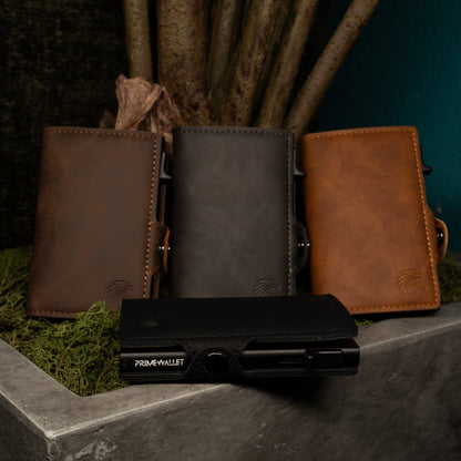 Vier Slim Wallets in Schwarz, Braun, Grau und Dunkelbraun – stilvolle Geldbörsen mit RFID-Schutz in natürlicher Umgebung.