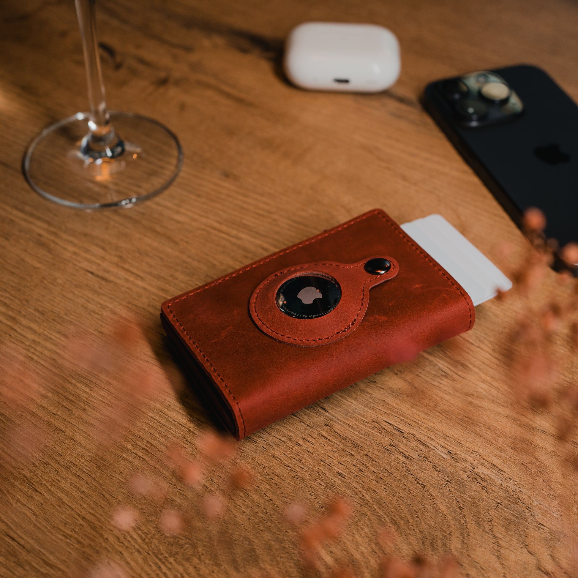 Edles Smart Wallet in Weinrot mit RFID-Schutz auf einem Holztisch. Perfekt für bis zu 10 Karten und mit integriertem AirTag-Fach.